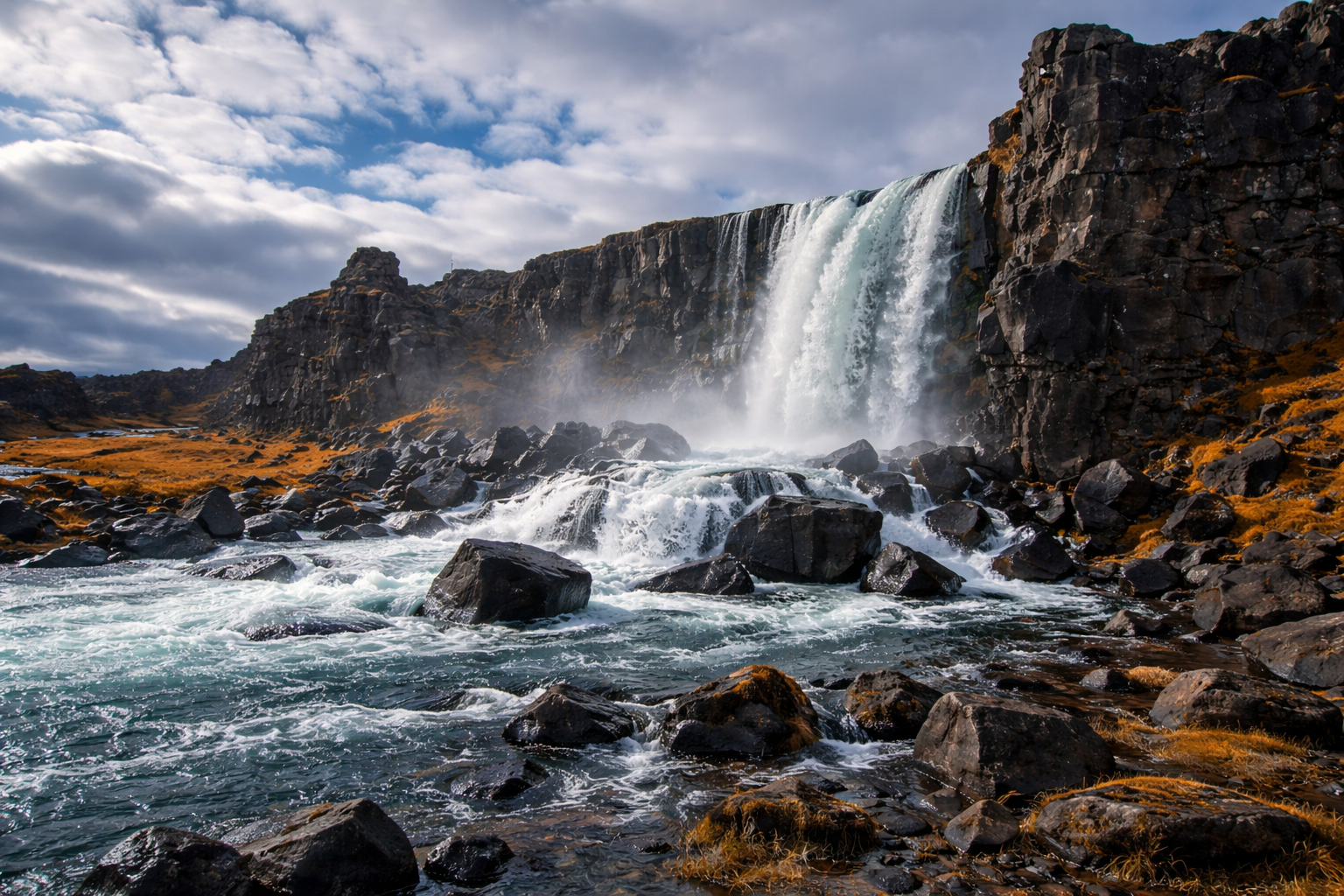 Öxarárfoss waterfall at Þingvellir National Park — the Öxará River cascading over dark basalt cliffs into a turquoise pool surrounded by autumn-coloured moss